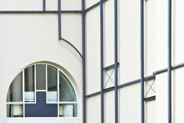 Nærbilde av en moderne bygning med store vinduer og metallrammer, som illustrerer en oppdatert og profesjonell nettside for bedrifter.